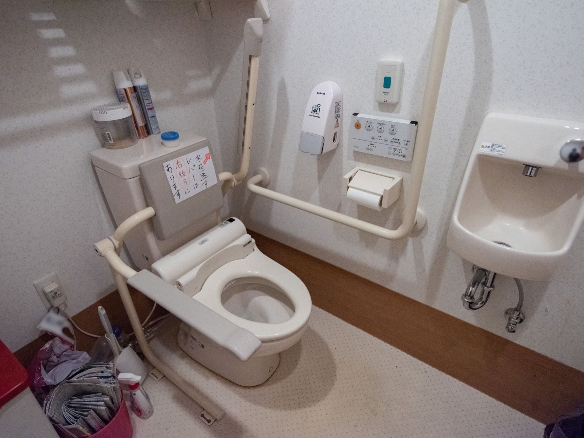 洗面台の付いた広いトイレがある。便座の両側には跳ね上げ式の手すりが付いており、立ち座り動作がしやすくなっている。