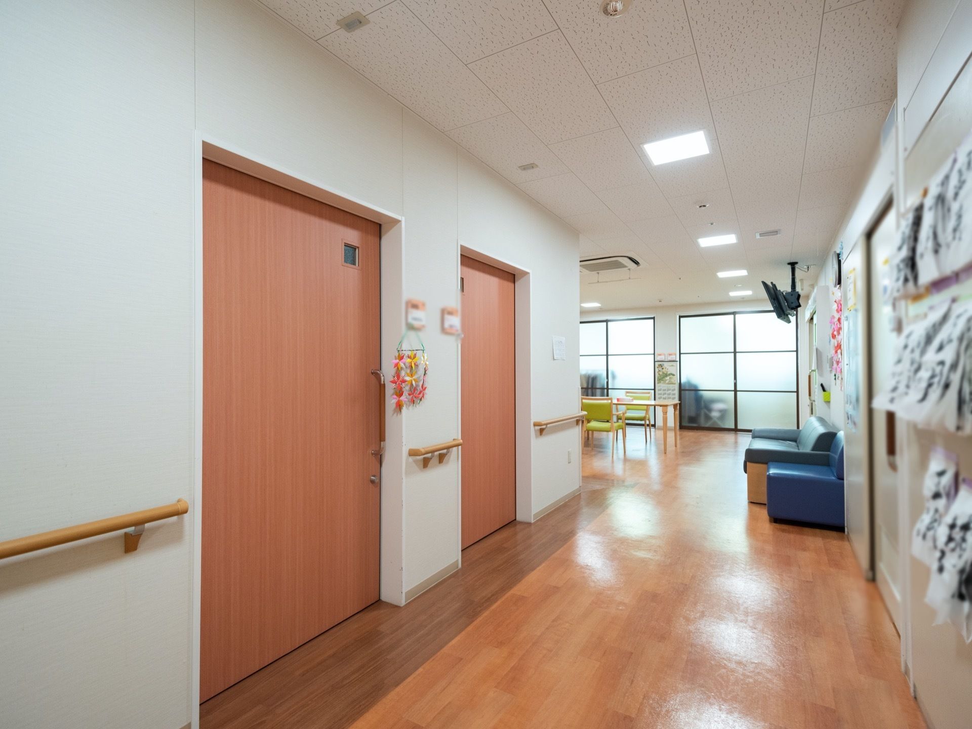 居室の入り口が並んでおり、間を縫うように手すりが設置された廊下