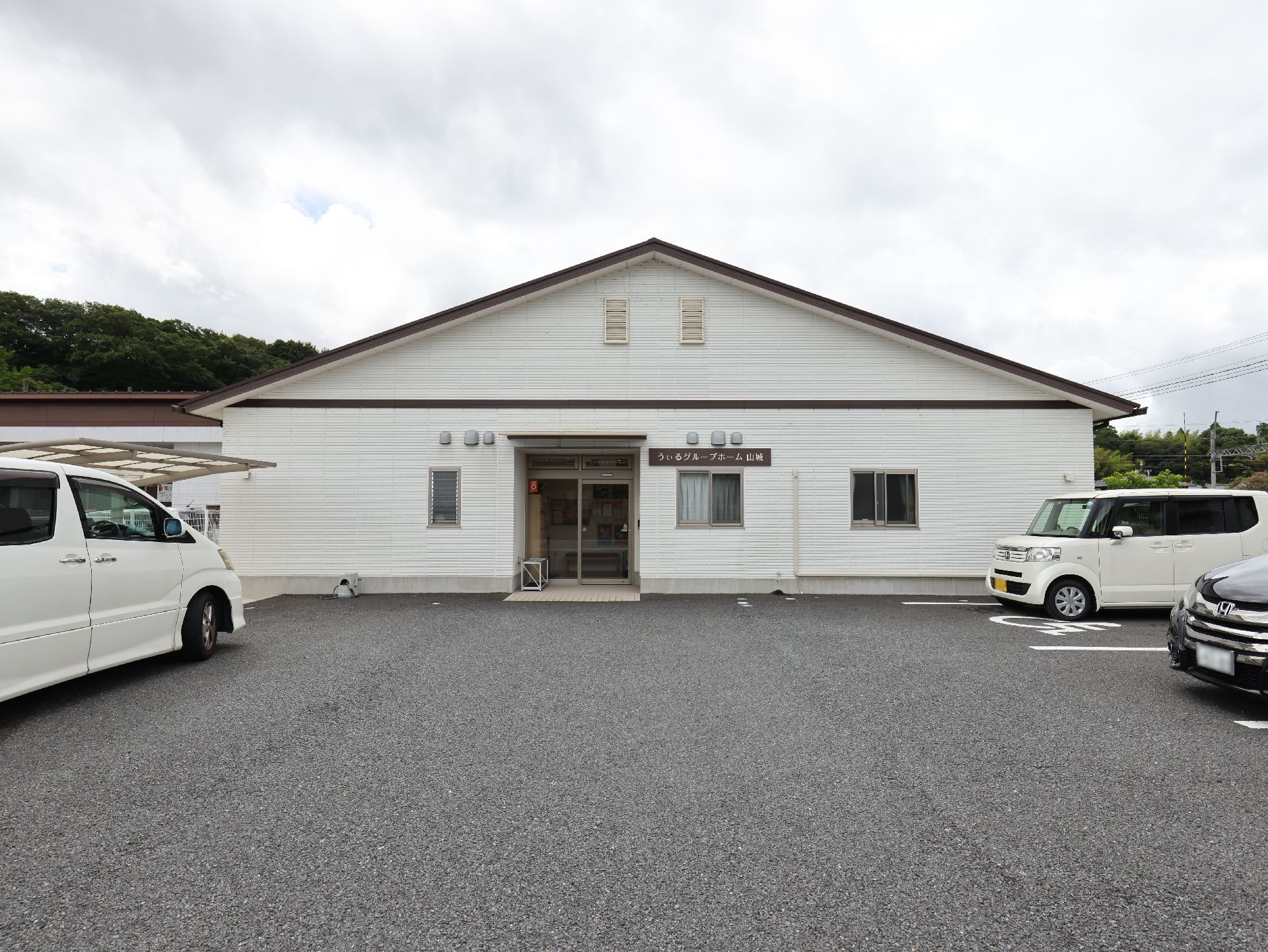 駐車場に隣接した白い外観の建物