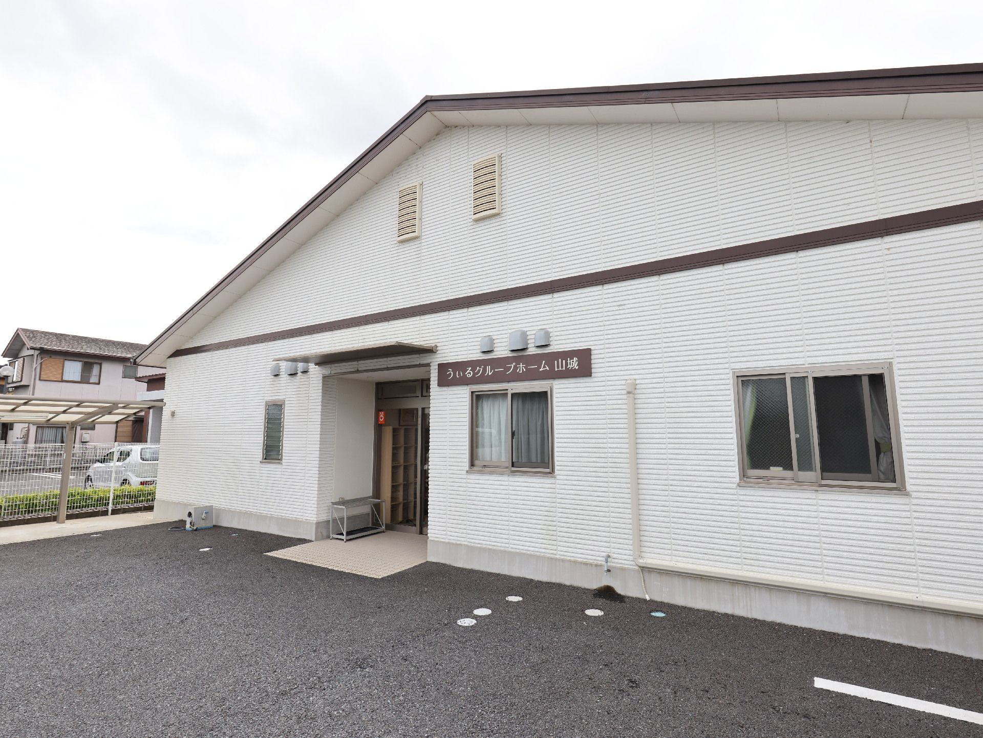 アスファルトに隣接した白い壁の建物