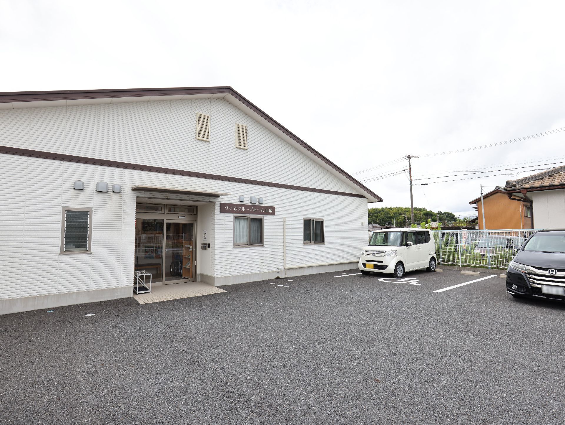 駐車場に隣接した白い壁の建物