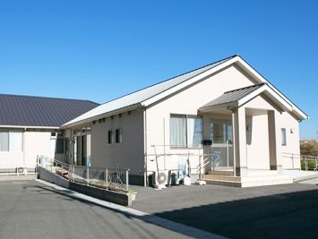 一軒家風のデザインの小さな建物の写真。エントランスの横にスロープらしいスペースがある