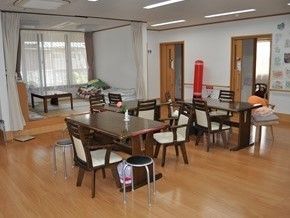 フローリングの床に家庭的なサイズの調度品が並んでいる様子。奥のほうにたたみのこ上りがある様子