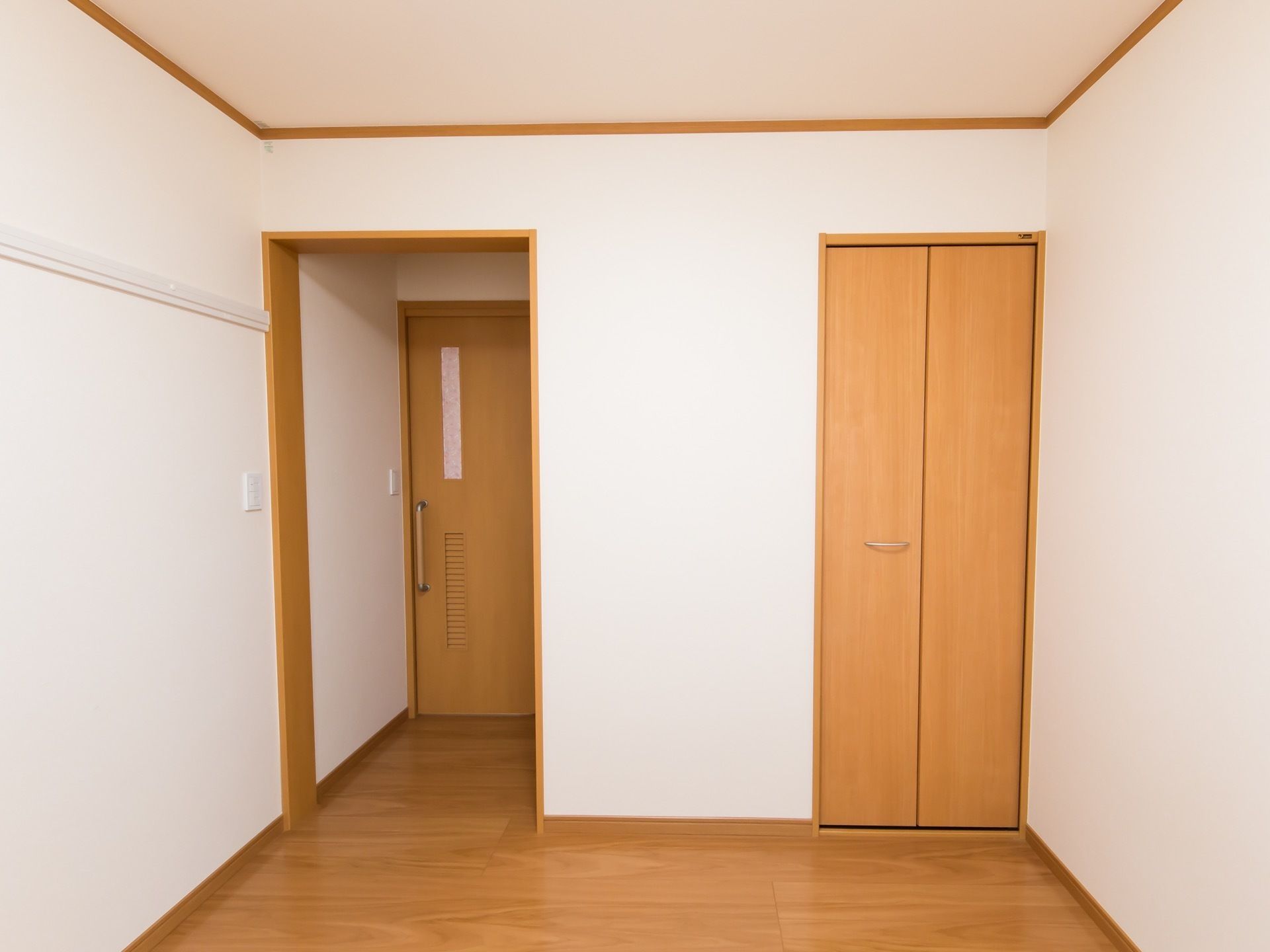 白と茶色で構成された、明るい居室である。入口の扉は引き戸となっている。また、壁際には収納スペースの扉がある。