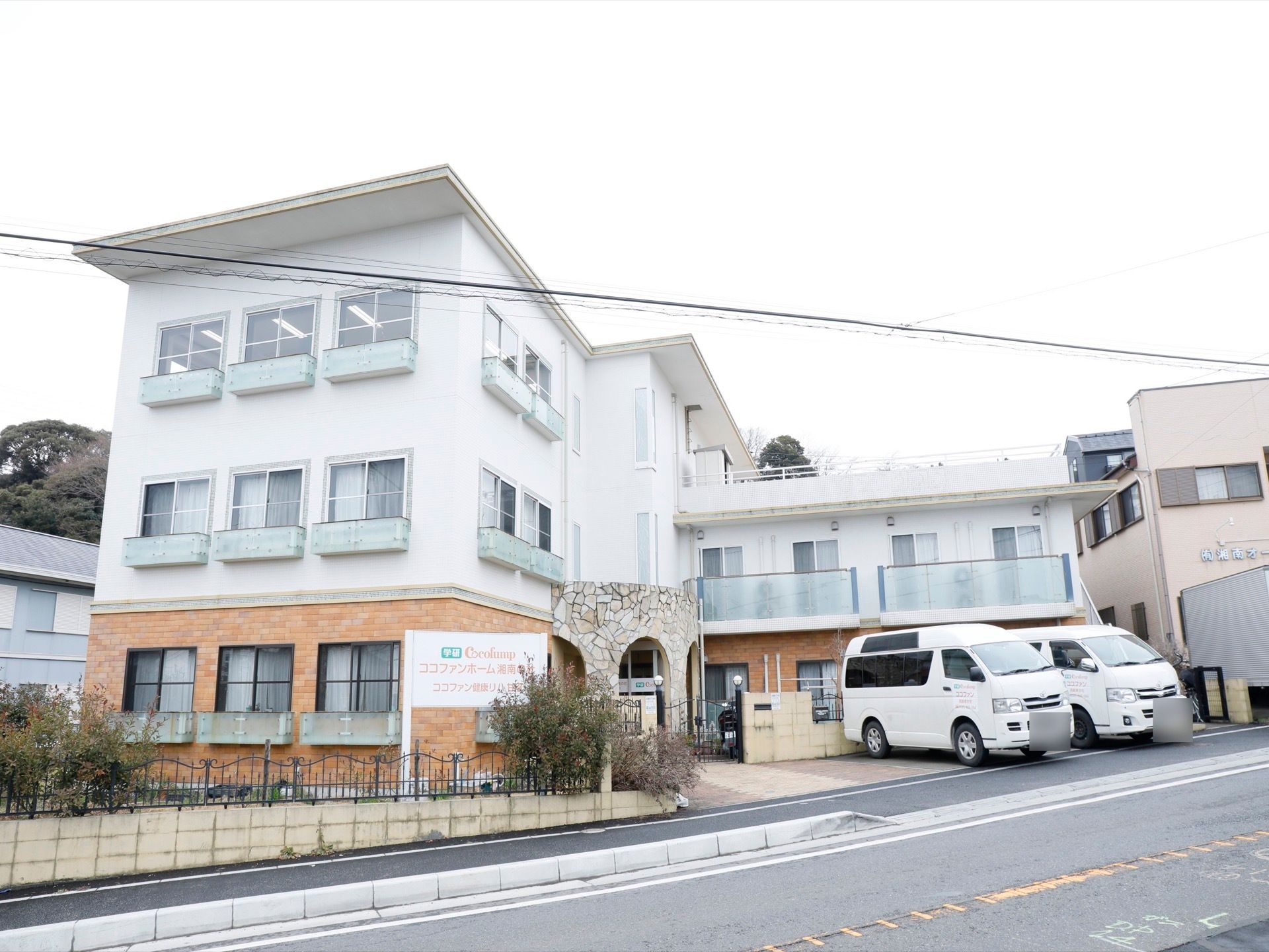 白い壁に、レンガを用いたスタイリッシュなつくりのホームである。四角い窓が均一に並び、ポーチと屋上がある。