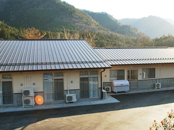 山々に囲まれた場所に建っている平屋建ての和風の住まいは一般の民家のようなたたずまい。