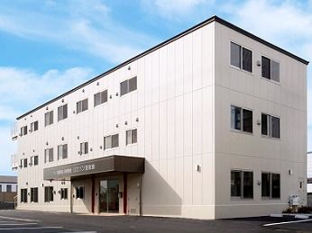 鉄骨造３階建ての建物の写真。無駄のない直線的デザインの建物の外観