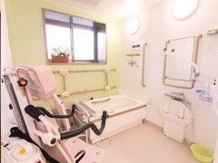 介護用設備がついた施設内の浴室の様子。座ったまま入れる設備が左側に置いてある様子