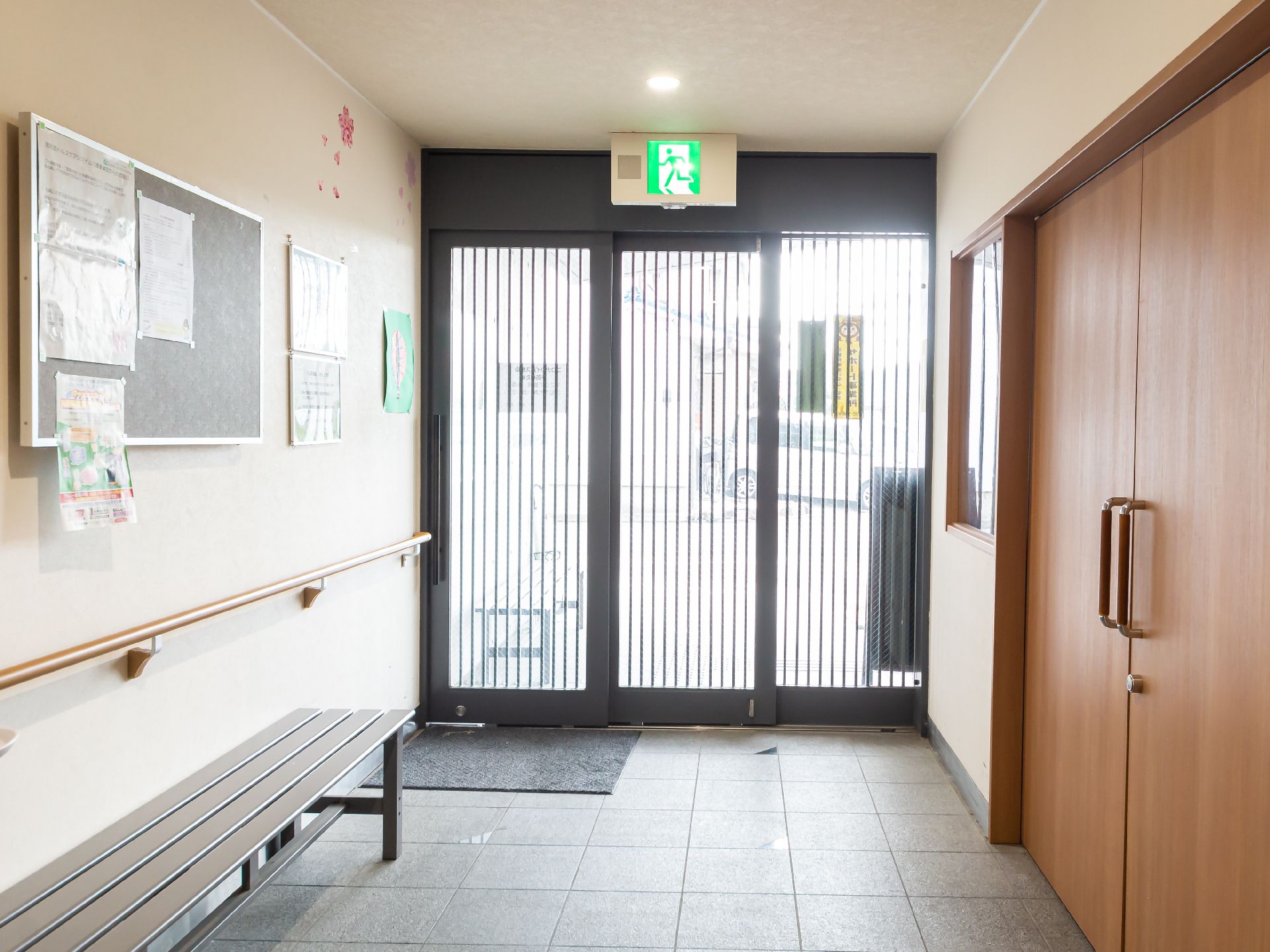 手すりやベンチが設置された高齢者施設の玄関
