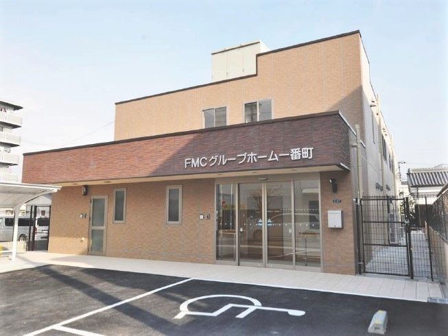 鉄骨造の建物の外観写真。ベージュと濃い茶色のツートンカラーが目を引く外観