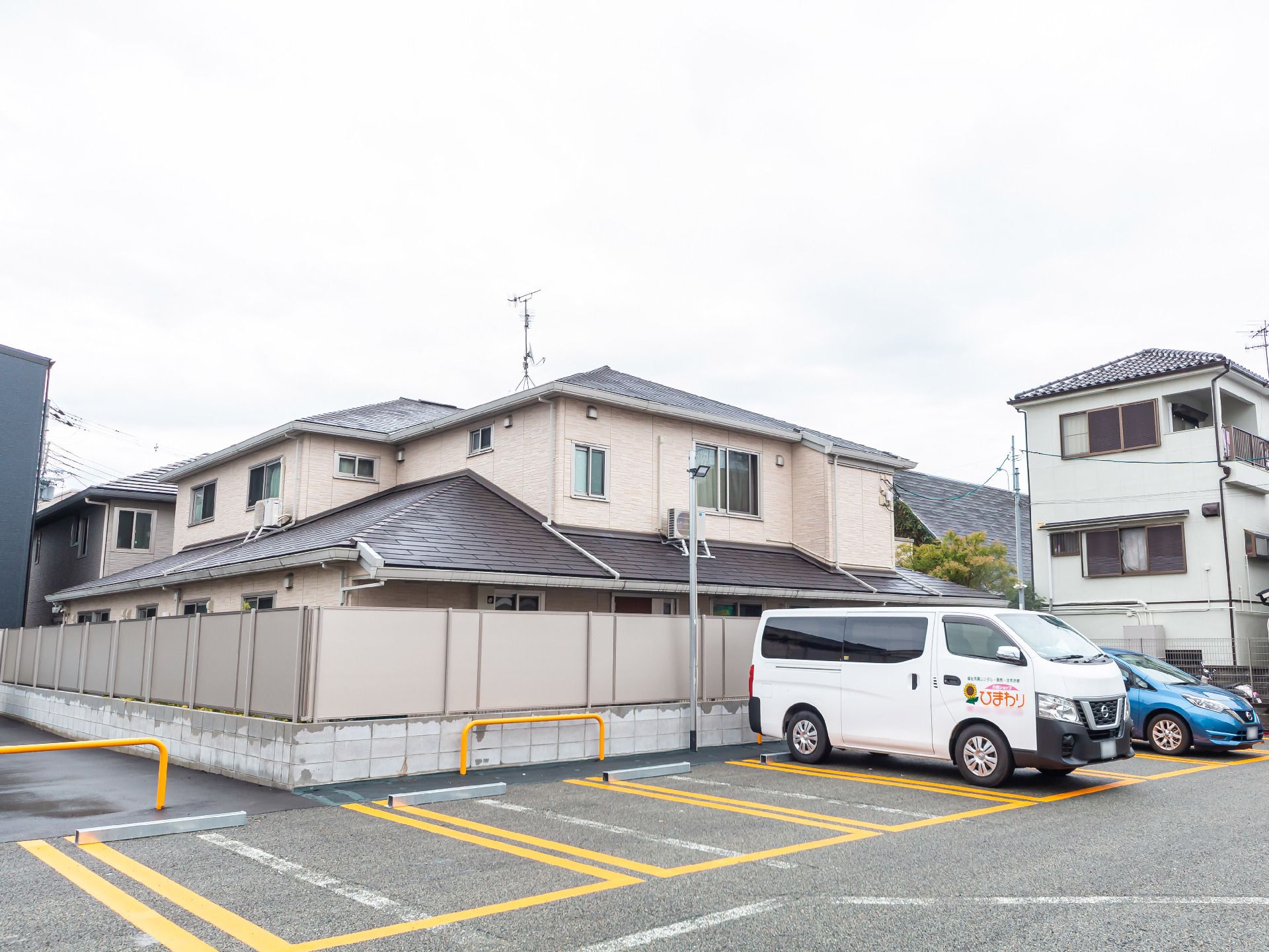 なにかを見て笑顔で手をたたいている高齢女性とスタッフの様子。施設での一場面の写真