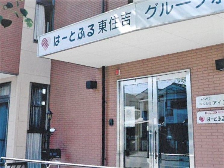 手すり付きのスロープや屋根が付いた玄関。レンガ調の壁が印象的。