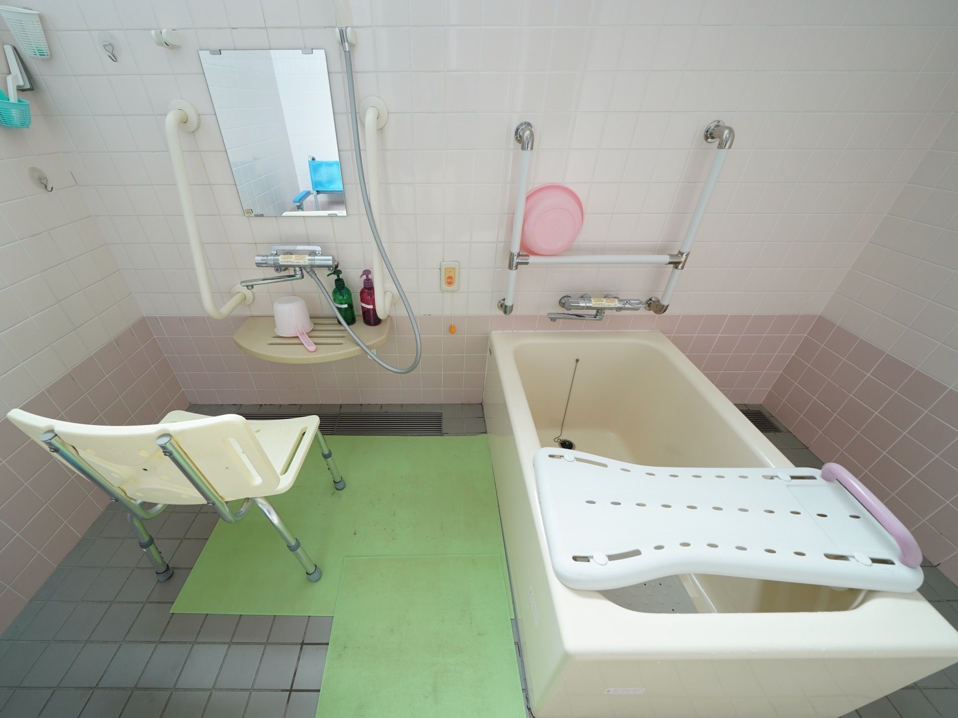 床は滑りにくい素材が使用されており、シャワー用チェアも備えられている。壁には手すりと緊急時のナースコールが設置されている。