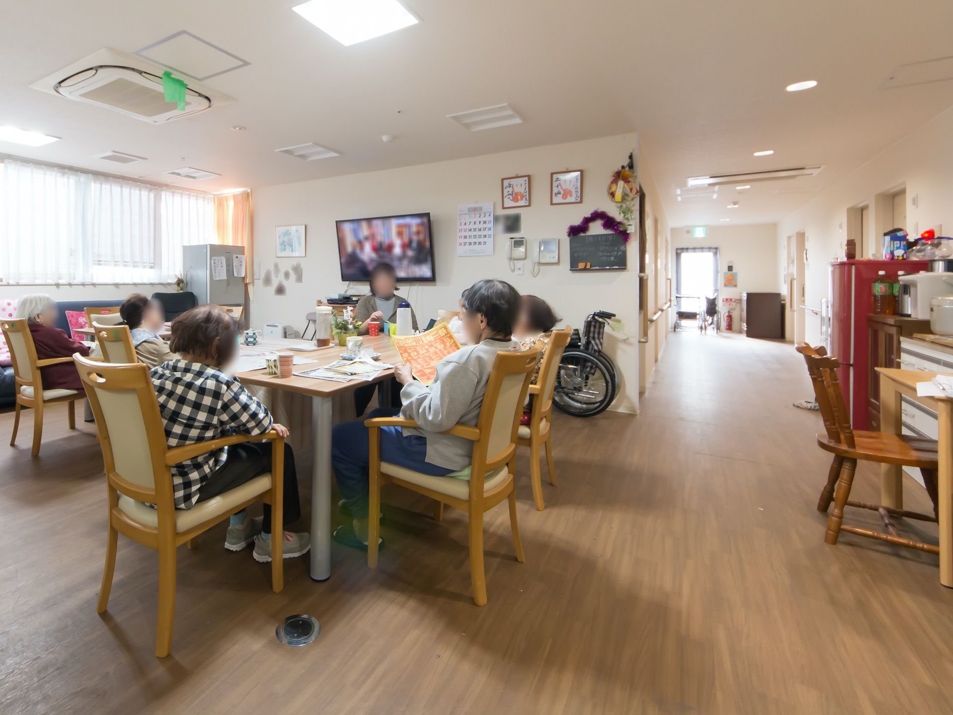 空調設備の整っている食堂で、廊下との間は仕切りがなく開放的である。テレビを観たり新聞を読んだりして、入居者様が寛いでいる。