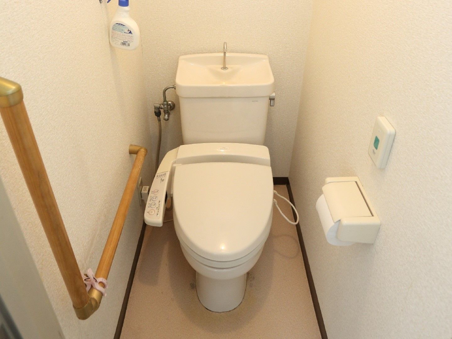 白い壁で清潔感のあるトイレである。壁には手すりや呼び出しボタンを設置しており、安心して安全に利用することができる。