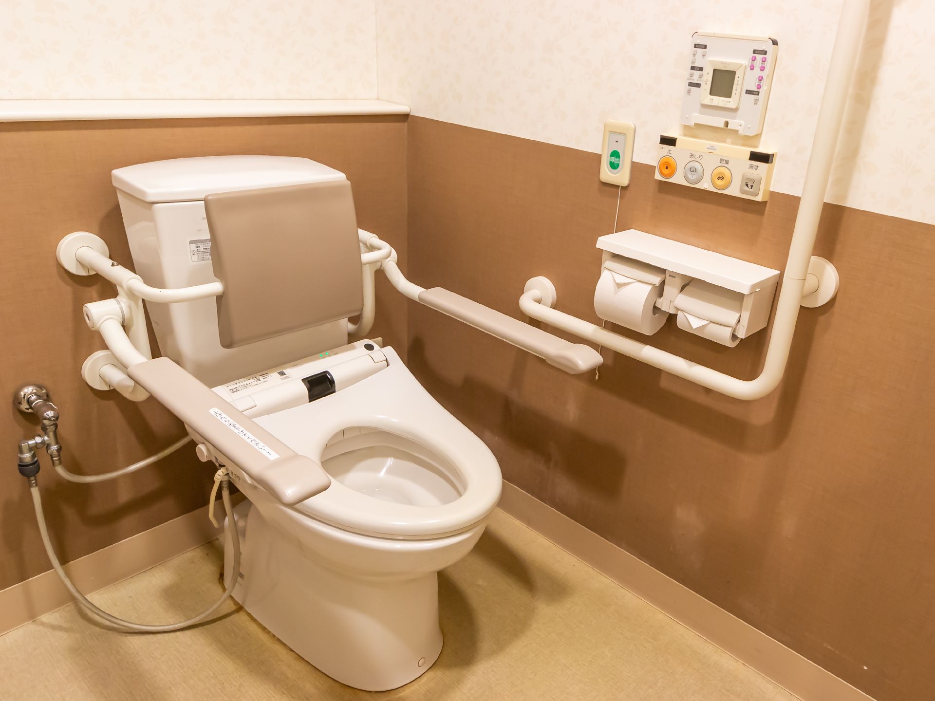 高齢者でも楽に座ることが可能な、手すりのついたトイレ