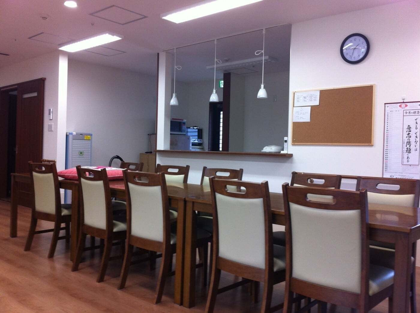 時計やカレンダーが設置されたダイニングの中央には大きなダイニングテーブルセットが置かれている。
