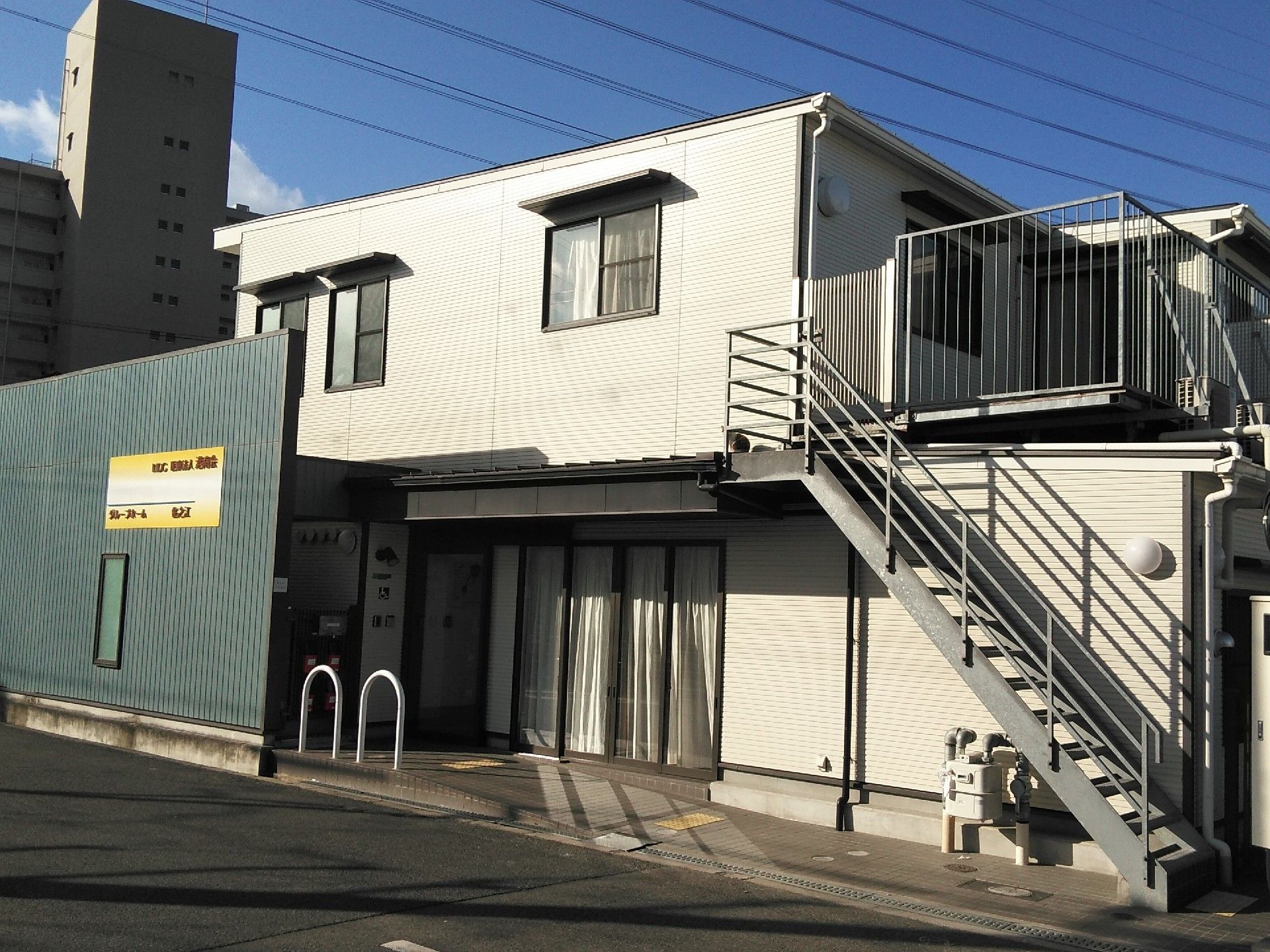 ２階建てのすっきりとした建物。ホワイト系で２階には１階から階段でも行くことができる。