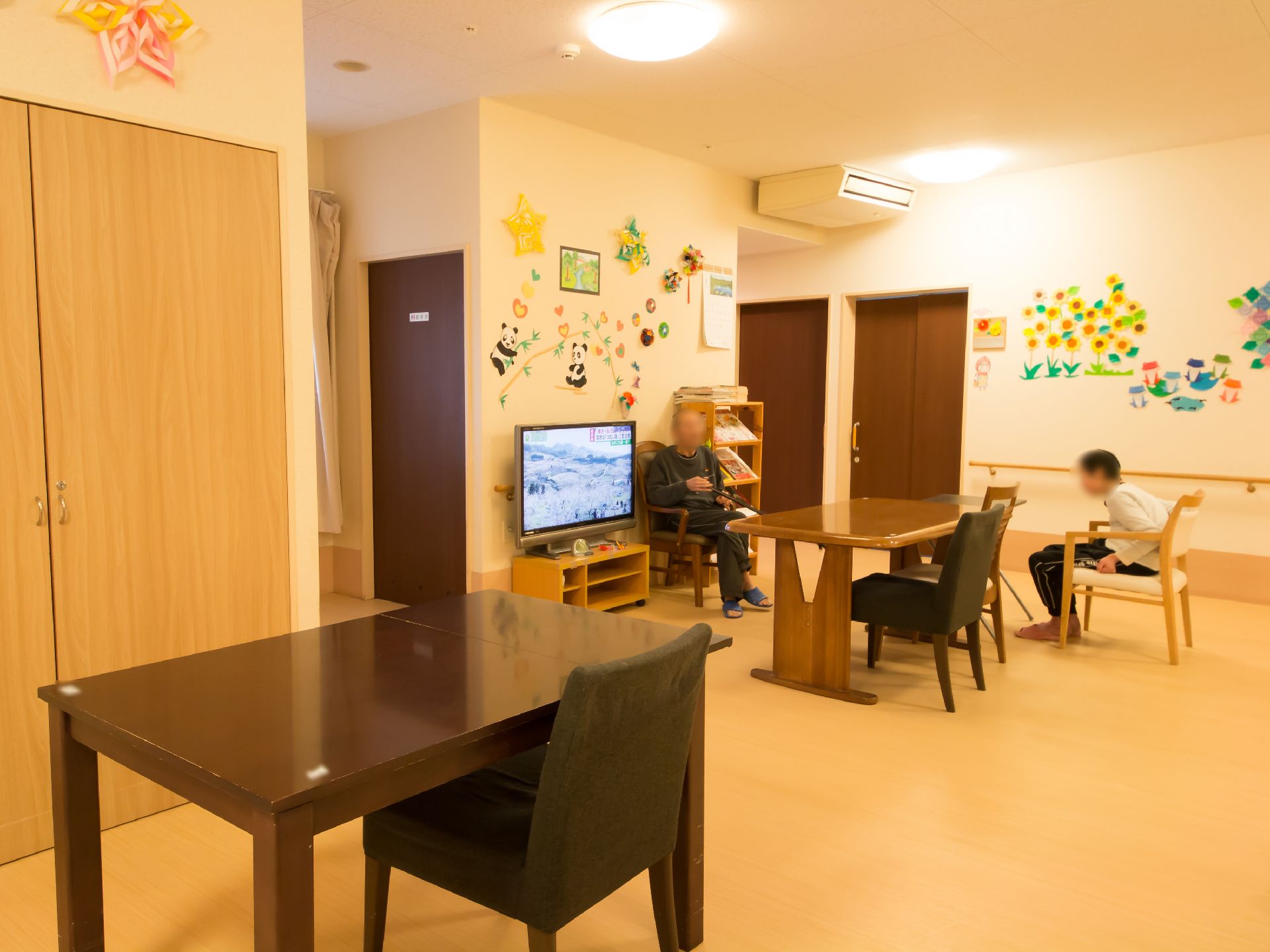 ゆったりと過ごせる雰囲気の共有スペースでは、入居者様がテレビを観たり、会話を楽しんだりしている。
