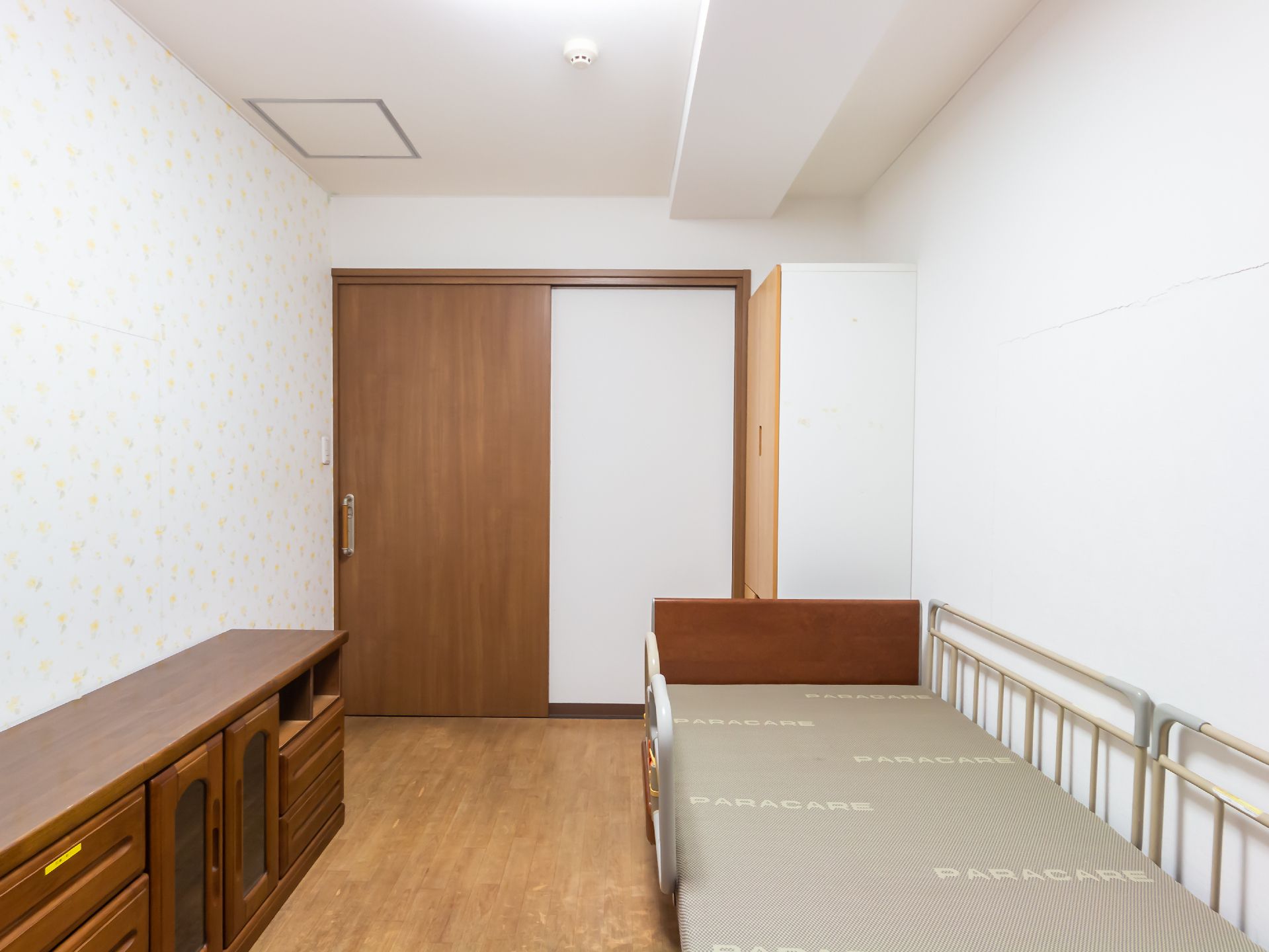 なにかを指さして笑顔で話している車いすの女性とそれを押している介護スタッフの様子