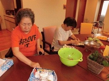 生活リハビリとして調理している様子。施設内のリビングで調理を手伝う高齢者の様子
