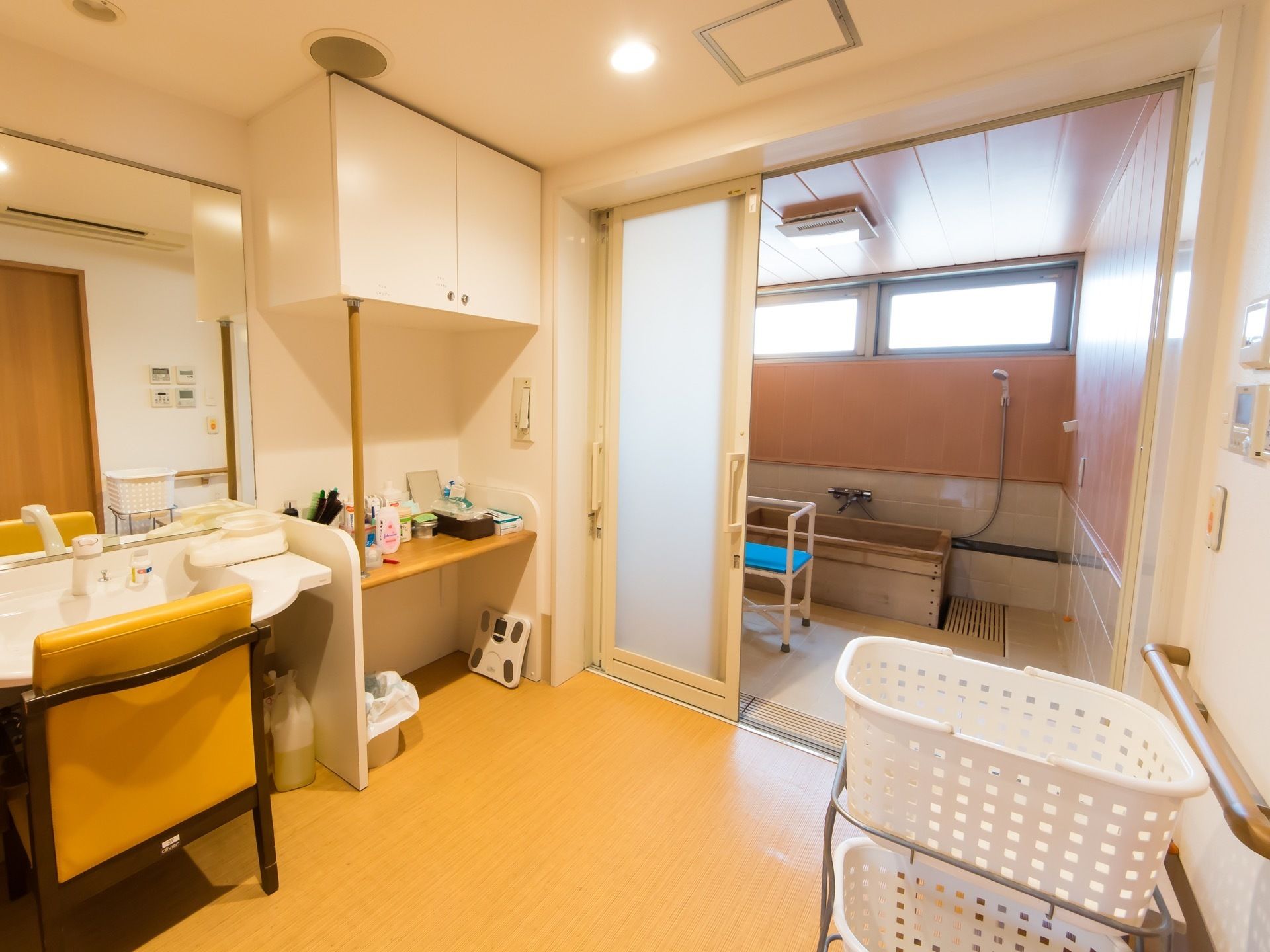 浴室の隣にある広い脱衣所。大きな鏡の付いた洗面台があり、椅子が用意されている。洗面道具が置かれている棚がある。