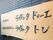 茶色の建物の壁面に、木の素材を活かした大きな看板が掛けられている。筆文字のようなフォントで施設名が書かれている。
