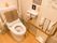 便器に背もたれが付いているトイレがある。壁には大きなＬ字型の手すりがある。温水洗浄便座が付いている。