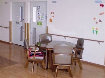 壁には手すりが設置され、折り紙で作った飾りも飾られ、ドアにもイラストが飾られている。ダイニングテーブルは４人掛け。