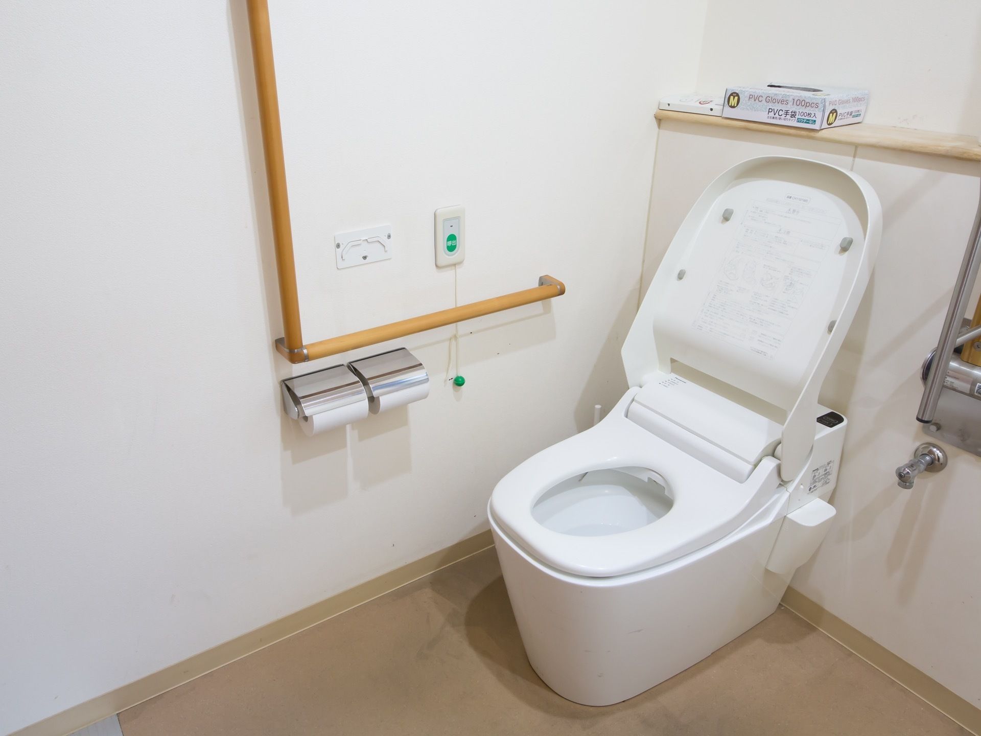 トイレはタンクがないタイプである。壁には大きな手すりが設置されていて、ナースコールボタンもついている。