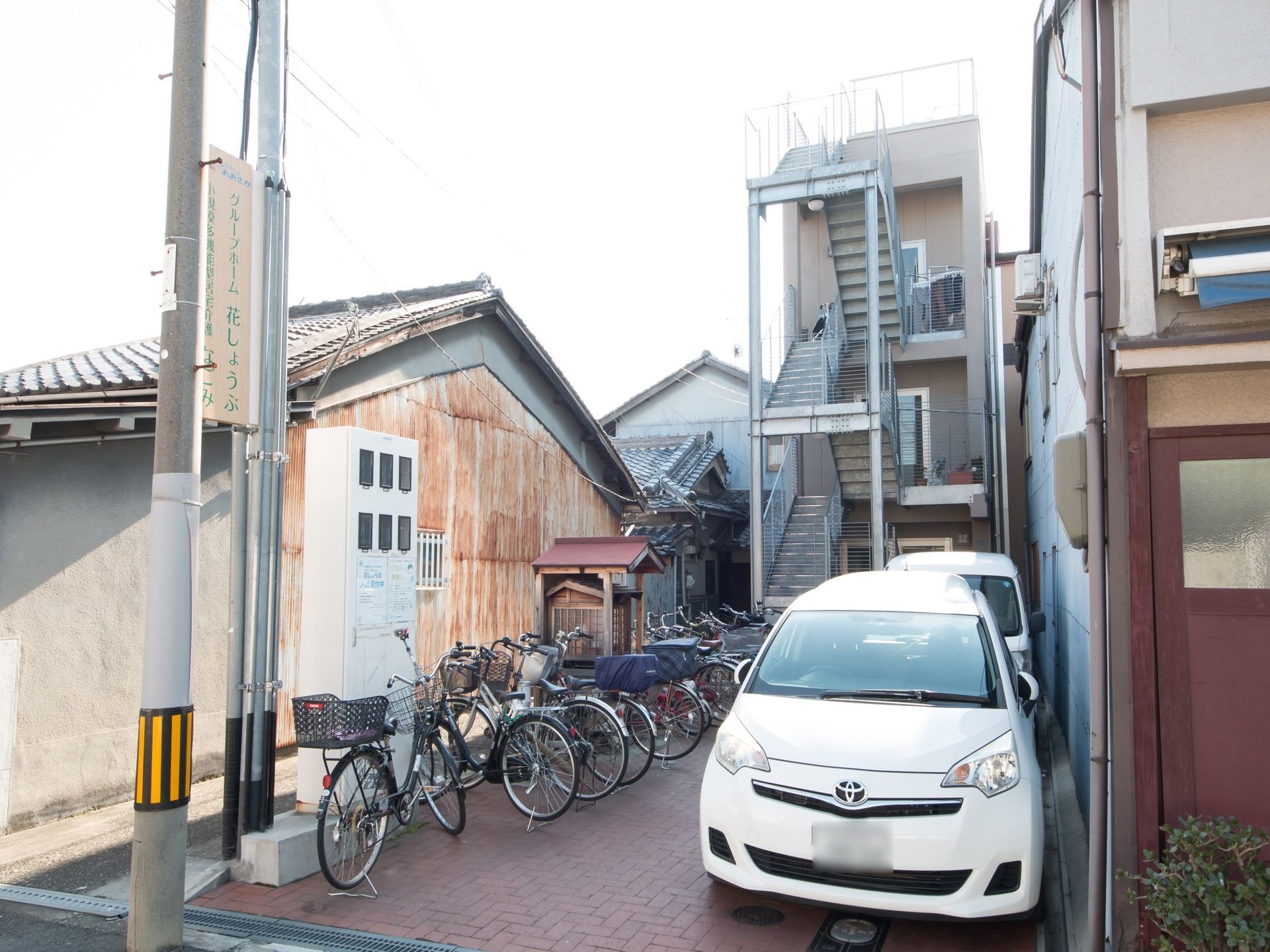 道路から奥まった所に建っている３階建ての施設である。道路沿いのポールに、施設名称が書かれた看板が設置されている。