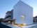グレーと白の３階建ての建物はデザイン性が高く、施設らしい雰囲気はない。玄関先には屋根がある。
