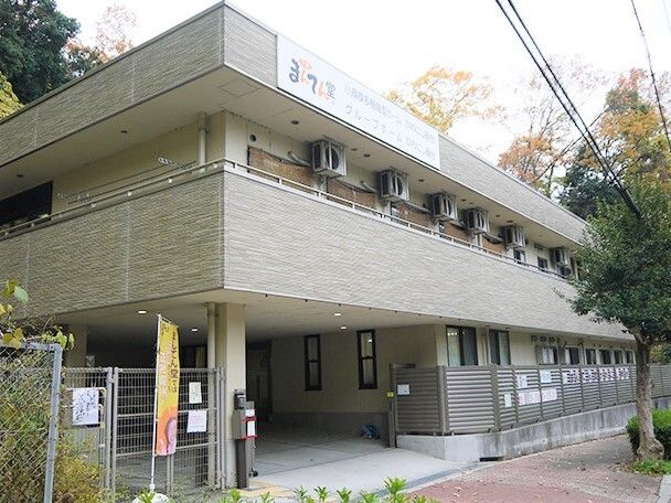 2階建ての建物はベージュ系で、2階にはベランダが付き、1階部分には駐車スペースが付いている。