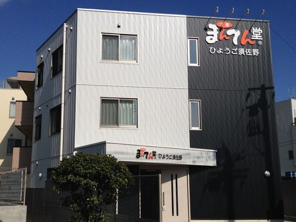 3階建ての建物はブラックトライとグレーで、ホーム名が書かれた屋根が玄関についている。