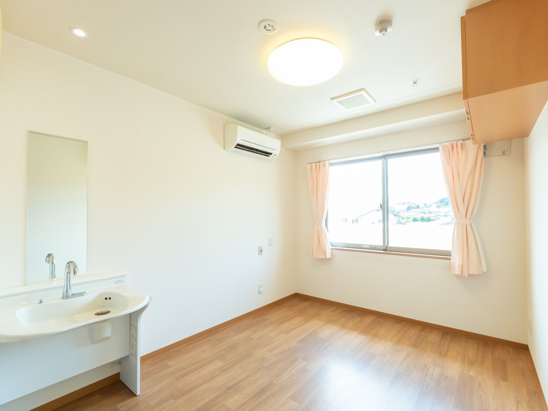 車いすの高齢の男女に若い男女のスタッフが付き添い、屋外で何かを鑑賞している。