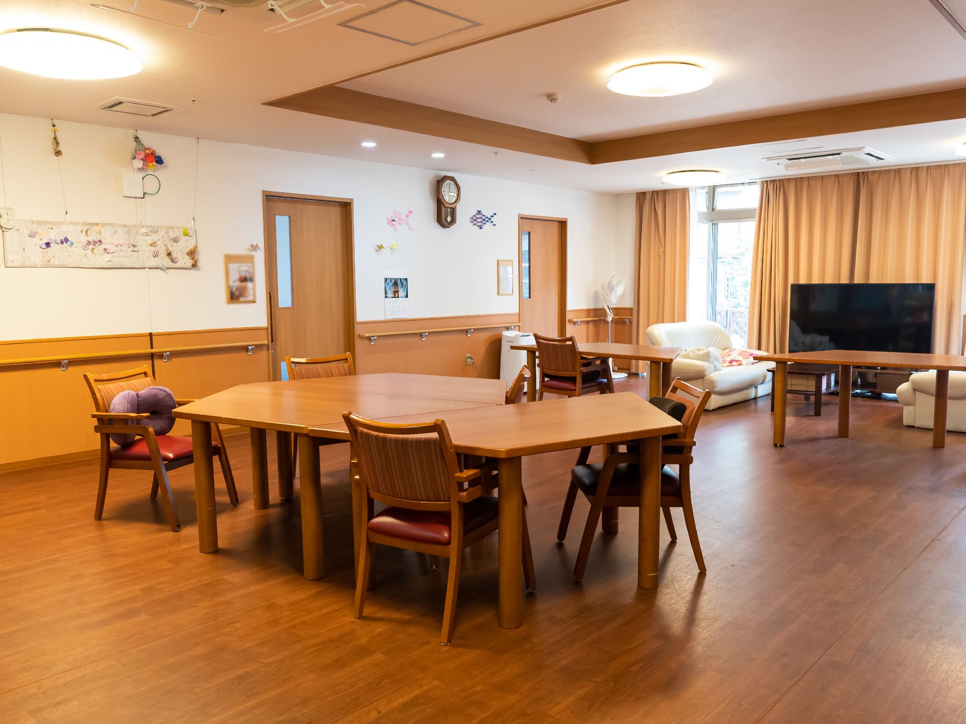 大きなテーブル、ソファーが置かれ、テレビが設置されているリビング