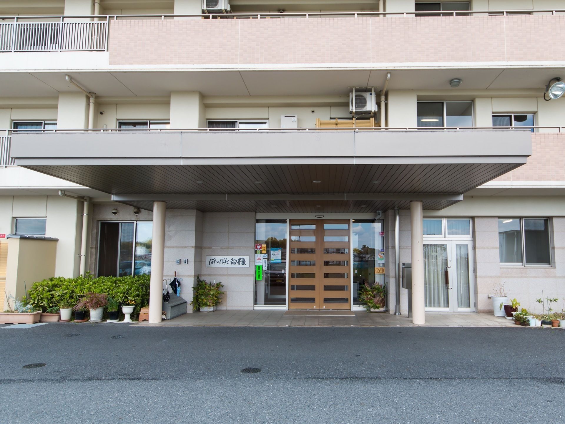 玄関は、木枠がついたガラス扉になっている。入口の左側には、施設名称を表示した看板が設置されている。玄関前には大きなひさしがついている。
