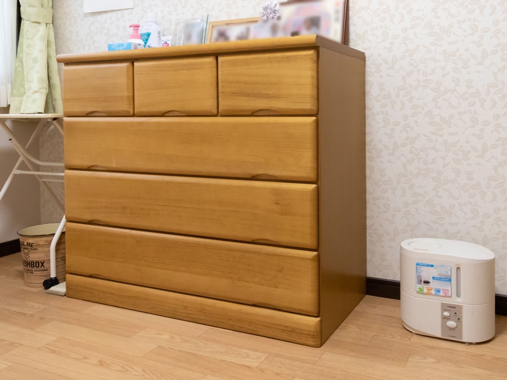 居室のタンスの上には写真や日用品が置かれている。隣には加湿器がある。床は段差がなく転倒に危険性が少ない。