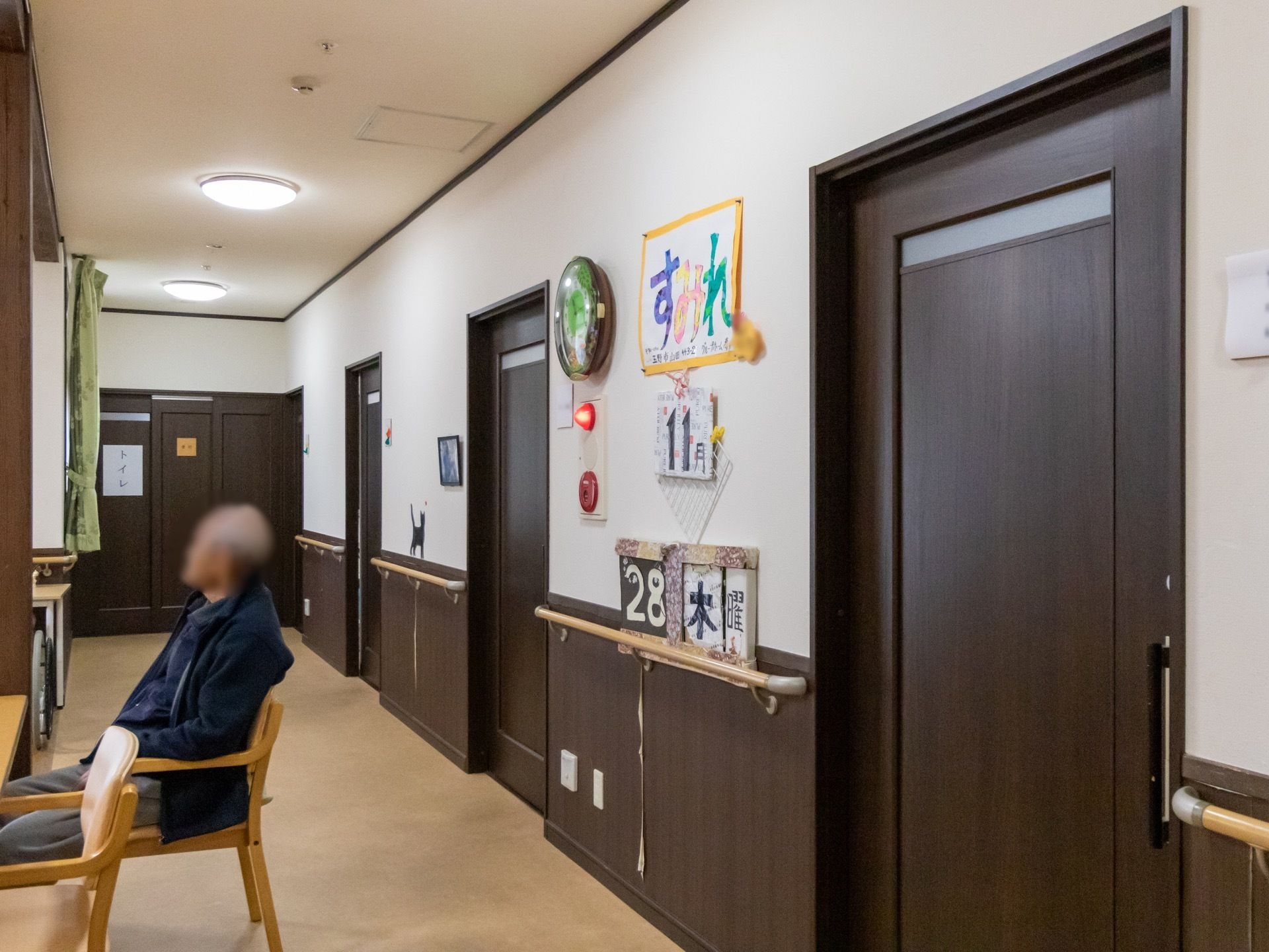 共有スペースの壁には大きな文字で日付が掲示されている。トイレの扉にも張り紙が貼られ、認知症対策が積極的に取り入れられている。