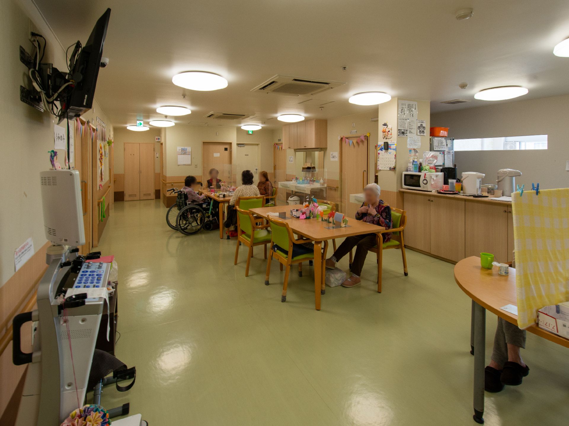 テーブルを挟んで椅子が置かれ、日差しが入っていて明るい共有スペース
