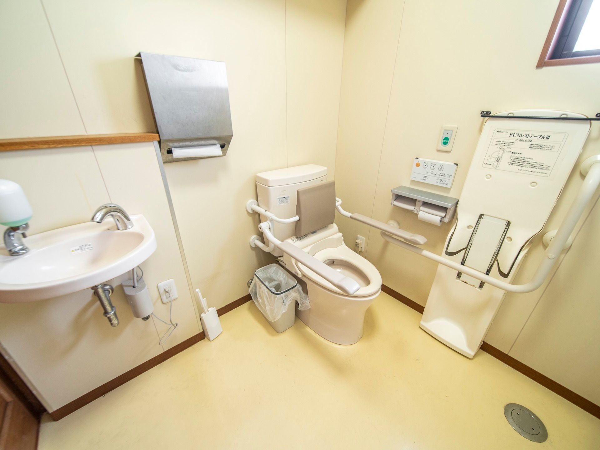 トイレの便座には肘置きと背もたれが備わっている。レストテーブルもあるので、体全体を乗せて安定した姿勢で利用することができる。