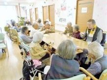 大きなダイニングテーブルが並び、入居者はおやつを食べている。