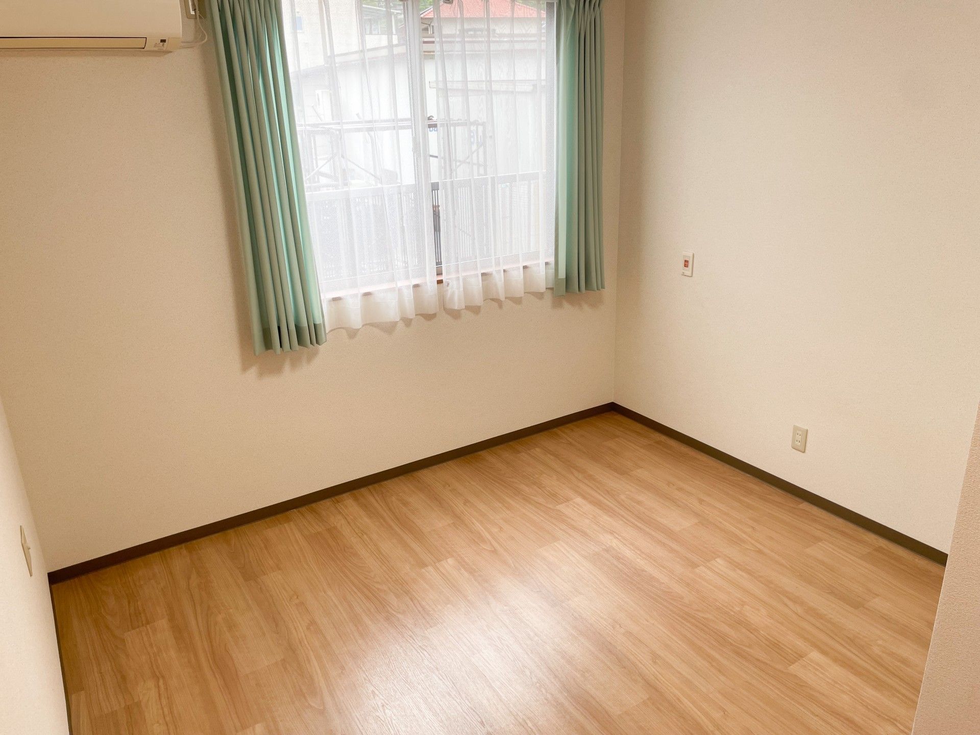 器具を引っ張りリハビリをする高齢女性と指導をする理学療法士の男性