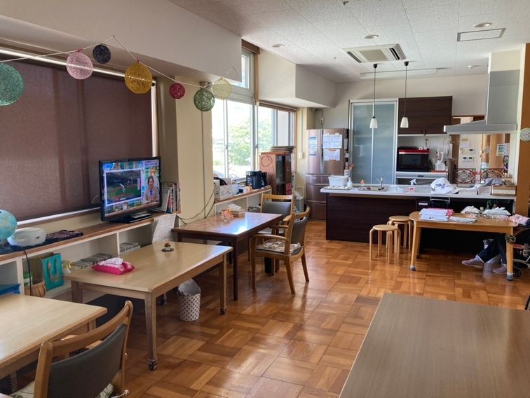 対面式キッチンが付いたリビングダイニングには家具や家電は置かれておらず、備え付けの食器棚がある。