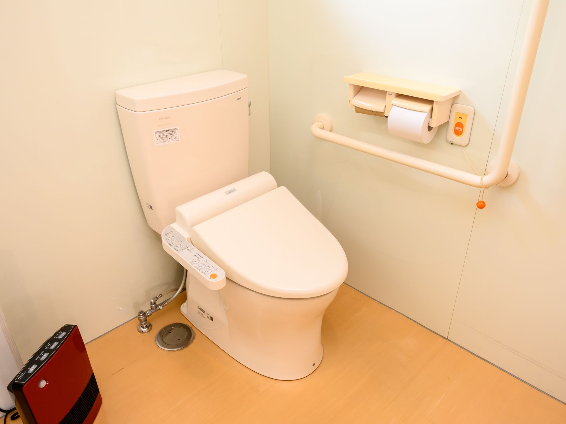 白い手すりとブザーが設置されたトイレ