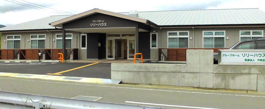 三角の瓦屋根がアットホームな雰囲気。和風の建物の周辺には広い駐車場があり、点字ブロックも敷かれている。