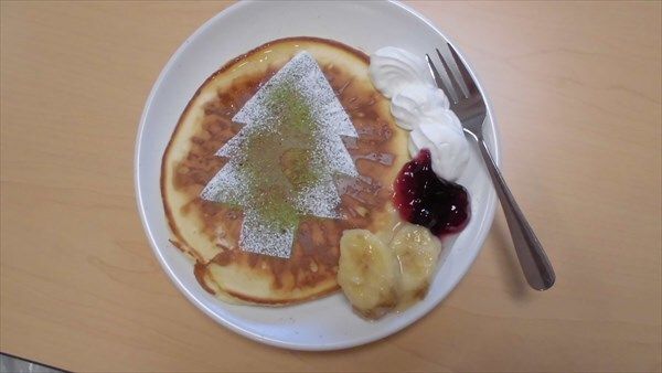シュガーパウダーでもみの木を描いたパンケーキバナナやクリームが添えられている