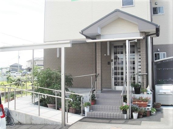車いす用のスロープ付きエントランスの様子。階段がありその向こうに出入り口がある