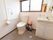 広いスペースにトイレと洗面台が設置されている。壁にはL字型に手すりが取りつけられており、呼び出しボタンもある。