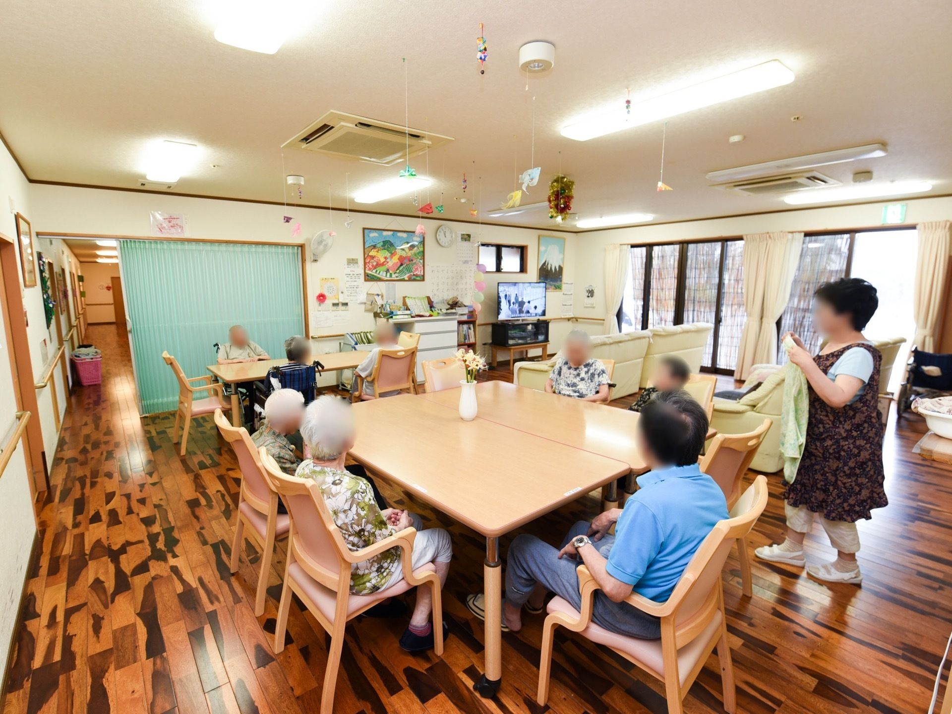 広いスペースに、ひじ掛け付きの椅子とテーブルを設置している。奥にはテレビやソファがあり、大勢でくつろぐことができる。